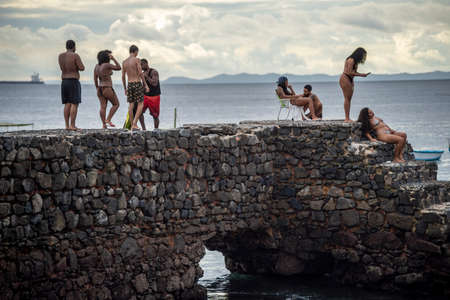 Salvador, Bahia, Brazil - June 01, 2021: People walking on the old pier of Santa Maria Fort in Porto da Barra on a cloudy day.のeditorial素材