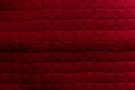 Red texture on bed cloth with divided into checkered parts. Salvador, Bahia, Brazil.