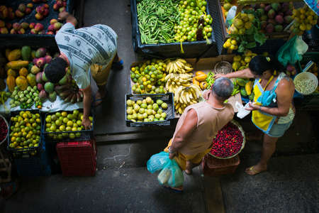 Camacari, Bahia, Brazil - October 17, 2015: People buying fruits, vegetables, and spices at the Camacari open market in Bahia, Brazil.のeditorial素材