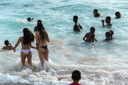 Salvador, Bahia, Brazil - January 08, 2019: People at Porto da Barra beach entering the sea of intense waves.のeditorial素材