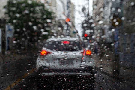 Salvador, Bahia, Brazil - June 13, 2021: Blurred colored lights through the car window with raindrops.の写真素材
