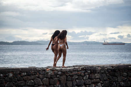 Salvador, Bahia, Brazil - June 01, 2021: People walking on the old pier of Santa Maria Fort in Porto da Barra on a cloudy day.の写真素材