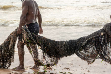 Salvador, Bahia, Brazil - January 11, 2020: Fishermen laying siege to fish with a large fishing net.の写真素材