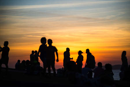 Salvador, Bahia, Brazil - June 12, 2021: Silhouette of people enjoying the wonderful colorful sunset of Farol da Barra in Salvador, Bahia.のeditorial素材