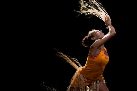 Contemporary dancer dancing in theater with black background and straw accessory. Salvador Bahia Brazil.の写真素材