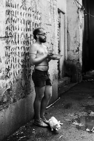 Man performs protest performance at the Sao Joaquim fair in Salvador. He is shirtless, holds a white...