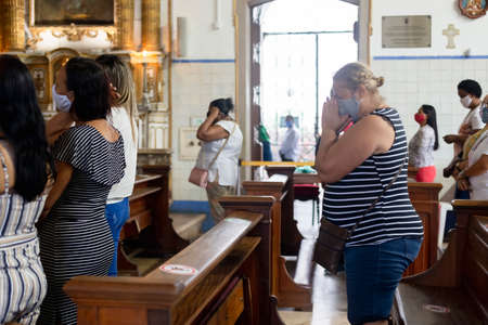 Salvador, Bahia, Brazil - July 25, 2020: People wearing face mask and praying at Senhor do Bonfim church in Salvador, Bahia, Brazil.のeditorial素材