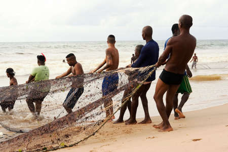 Salvador, Bahia, Brazil - January 11, 2019: Fishermen pulling their fishing net out of the sea.のeditorial素材