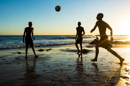 Salvador, Bahia, Brazil - January 08, 2020: Young people playing sand football at sunset on Ondina beach in Salvador, Bahia, Brazil.のeditorial素材
