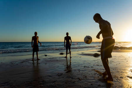 Salvador, Bahia, Brazil - January 08, 2020: Young people playing sand football at sunset on Ondina beach in Salvador, Bahia, Brazil.のeditorial素材