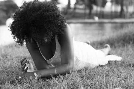 Beautiful model in white dress smiling and looking at camera. In the background, trees, plants, flowers and the river in the landscape. Salvador Bahia Brazil.の写真素材