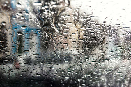 Wet glass, car inside view of street with buildings and houses. Salvador, Bahia, Brazil.の写真素材