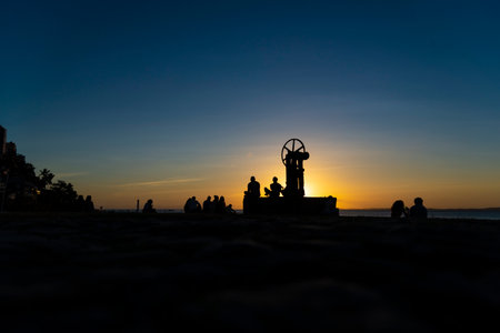 Silhouette of group of people enjoying the sunset. Salvador, Bahia, Brazil.の写真素材