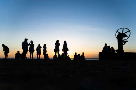 Silhouette of group of people enjoying the sunset. Salvador, Bahia, Brazil.の写真素材
