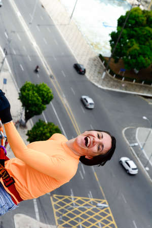 A female rappellist descending the elevator lacerates. Very tall monument. Salvador Bahia Brazil.