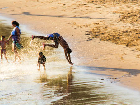 Salvador, Bahia, Brazil - January 05, 2019: Young man running in the waters and sand of Paciencia beach in Rio Vermelho. Salvador Bahia Brazil.のeditorial素材