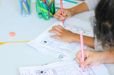 Hands with colored pencils drawing on paper. Salvador, Bahia, Brazil.の写真素材