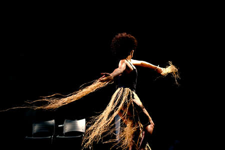 Portrait of a woman dancing on stage against black background. Salvador, Bahia, Brazil.の写真素材