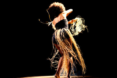 Portrait of a woman dancing on stage against black background. Salvador, Bahia, Brazil.の写真素材