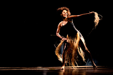 Portrait of a woman dancing on stage against black background. Salvador, Bahia, Brazil.の写真素材