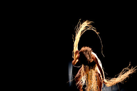 Portrait of a woman dancing on stage against black background. Salvador, Bahia, Brazil.の写真素材