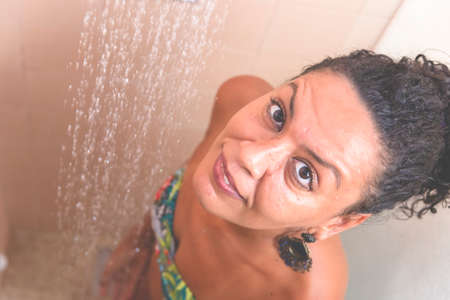 Portrait of a woman in the bathroom washing herself. Salvador, Bahia, Brazil.