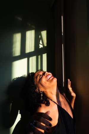 Portrait of a woman against light and shadow background. Salvador, Bahia, Brazil.の写真素材