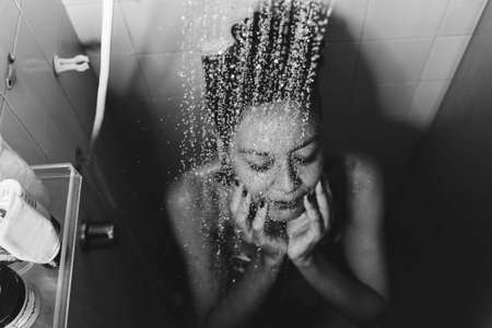 Portrait of a woman in the bathroom washing herself. Salvador, Bahia, Brazil.の写真素材