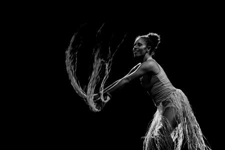 Contemporary dancer dancing in theater with black background and straw accessory. Salvador Bahia...