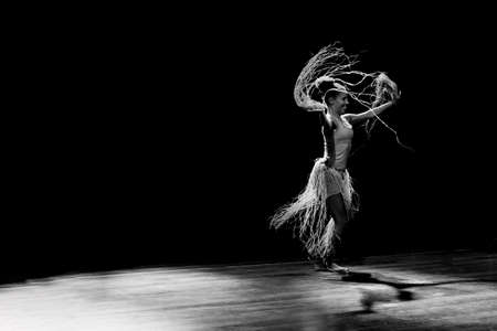 Contemporary dancer dancing in theater with black background and straw accessory. Salvador Bahia Brazil.の写真素材