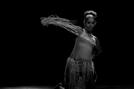 Contemporary dancer dancing in theater with black background and straw accessory. Salvador Bahia Brazil.の写真素材