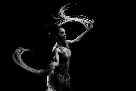 Contemporary dancer dancing in theater with black background and straw accessory. Salvador Bahia...