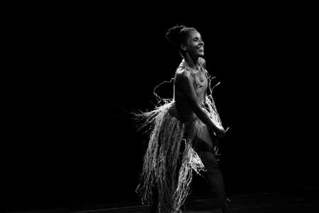 Contemporary dancer dancing in theater with black background and straw accessory. Salvador Bahia Brazil.の写真素材