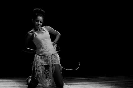 Contemporary dancer dancing in theater with black background and straw accessory. Salvador Bahia...