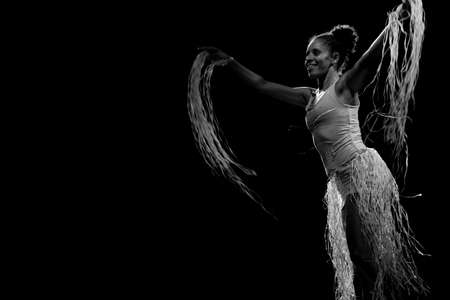 Contemporary dancer dancing in theater with black background and straw accessory. Salvador Bahia Brazil.の写真素材