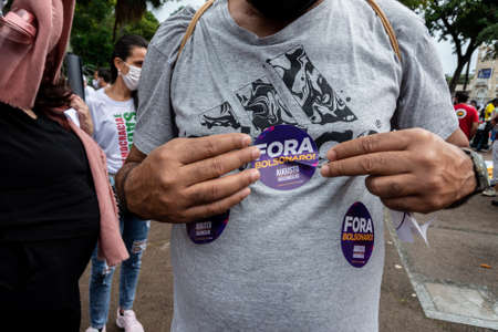 Salvador, Bahia, Brazil - July 24, 2021: People protest against the government of President Jair Bolsonaro in the city of Salvador. They use banners, posters, stickers and masks with slogans.のeditorial素材
