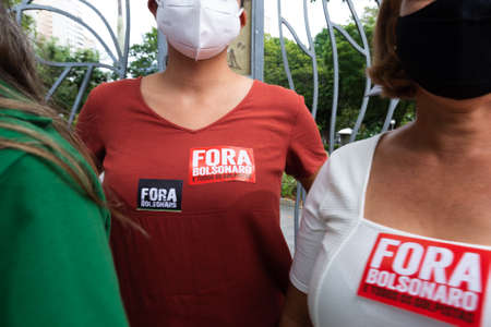 Salvador, Bahia, Brazil - July 24, 2021: People protest against the government of President Jair Bolsonaro in the city of Salvador. They use banners, posters, stickers and masks with slogans.のeditorial素材