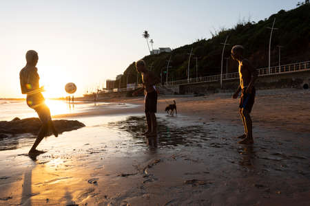 Salvador, Bahia, Brazil - January 08, 2020: Young people playing sand football at sunset on Ondina beach in Salvador, Bahia, Brazil.のeditorial素材