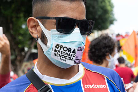 Salvador, Bahia, Brazil - July 24, 2021: People protest against the government of President Jair Bolsonaro in the city of Salvador. They use banners, posters, stickers and masks with slogans.のeditorial素材