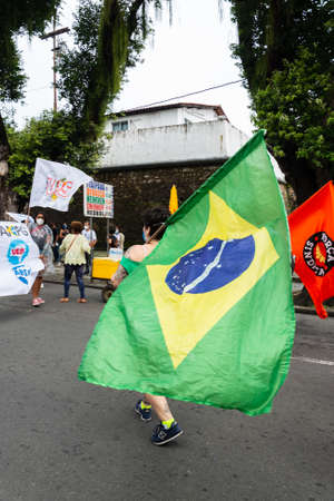 Salvador, Bahia, Brazil - July 24, 2021: People protest against the government of President Jair Bolsonaro in the city of Salvador. They use banners, posters, stickers and masks with slogans.のeditorial素材