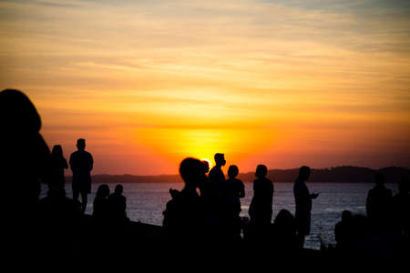 Salvador, Bahia, Brazil - June 12, 2021: Silhouette of people enjoying the wonderful colorful sunset of Farol da Barra in Salvador, Bahia.のeditorial素材