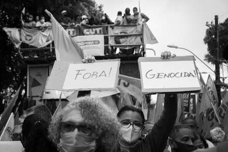 Salvador, Bahia, Brazil - July 24, 2021: People protest against the government of President Jair Bolsonaro in the city of Salvador. They use banners, posters, stickers and masks with slogans.のeditorial素材