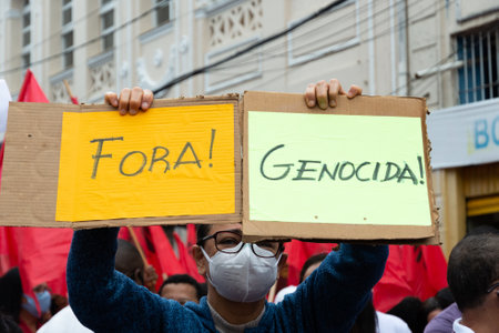 Salvador, Bahia, Brazil - July 24, 2021: People protest against the government of President Jair Bolsonaro in the city of Salvador. They use banners, posters, stickers and masks with slogans.のeditorial素材
