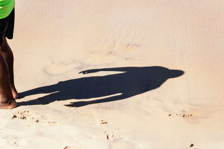 Lower part of a person and his shadow on the beach sand. Salvador Bahia Brazil.
