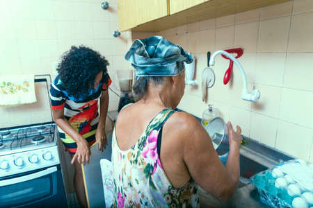 Mother and daughter in the kitchen making food. Salvador, Bahia, Brazil.の写真素材