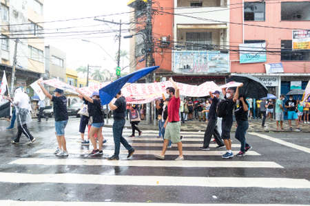Salvador, Bahia, Brazil - July 24, 2021: People protest against the government of President Jair Bolsonaro in the city of Salvador. They use banners, posters, stickers and masks with slogans.のeditorial素材