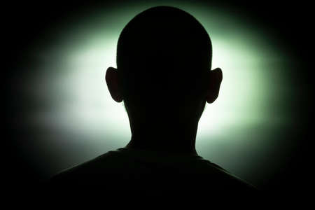 Close-up silhouette of a man's head against a green background. Salvador, Bahia, Brazil.の写真素材