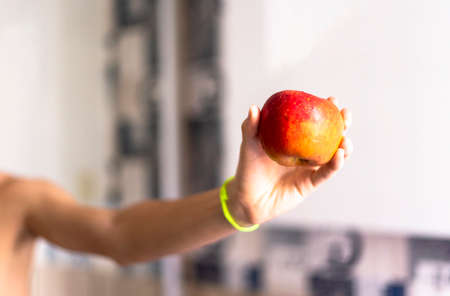 A hand holding an apple against white background. Salvador, Bahia, Brazil.の写真素材