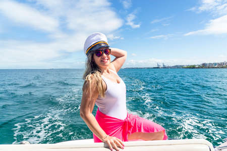 A woman on top of a boat against the sea in the background. Salvador, Bahia, Brazil.