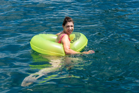 Woman in a bikini in the sea water with a buoy. Salvador Bahia Brazil.